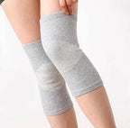 Gray knee sleeves on a person's legs against a white background